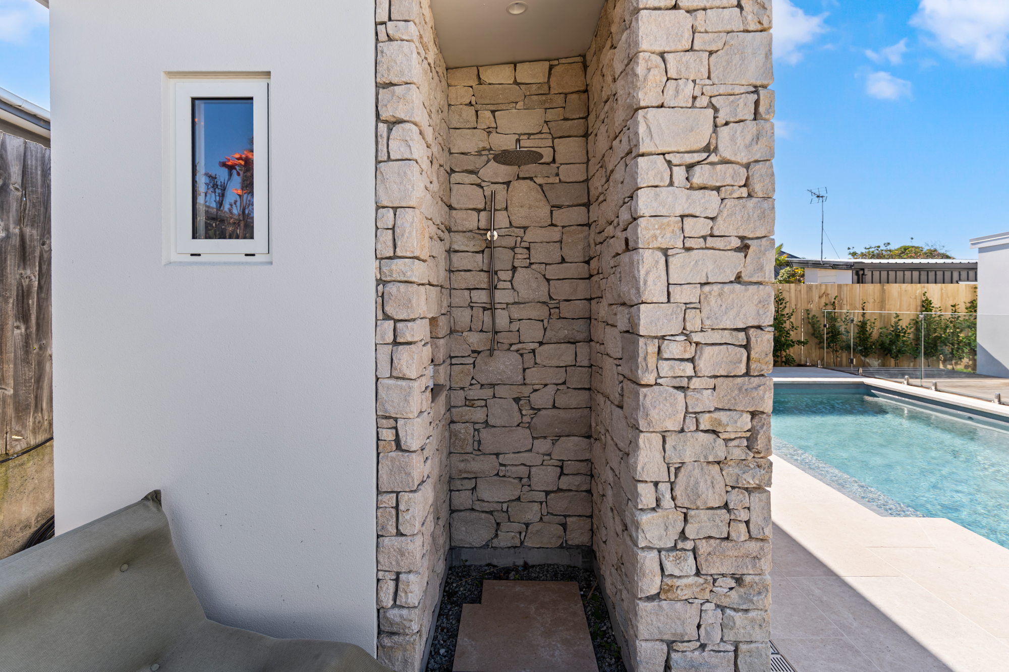 Marine Parade - outdoor stone shower with limestone walls and pool view