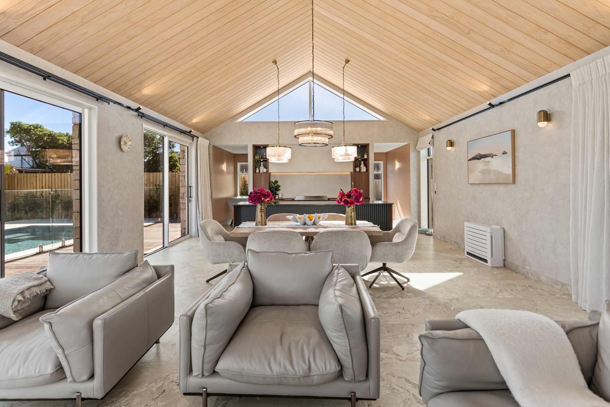 Marine Parade - dining and lounge with vaulted cedar ceiling, stone feature wall, and natural light