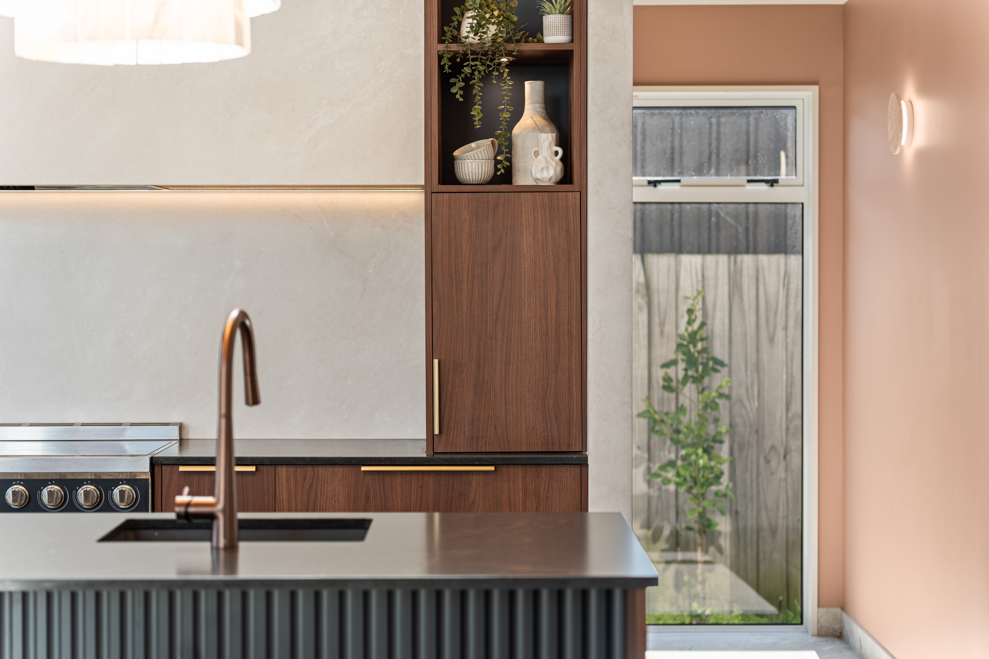 Marine Parade - kitchen detail with copper tap, walnut joinery, and stone benchtop