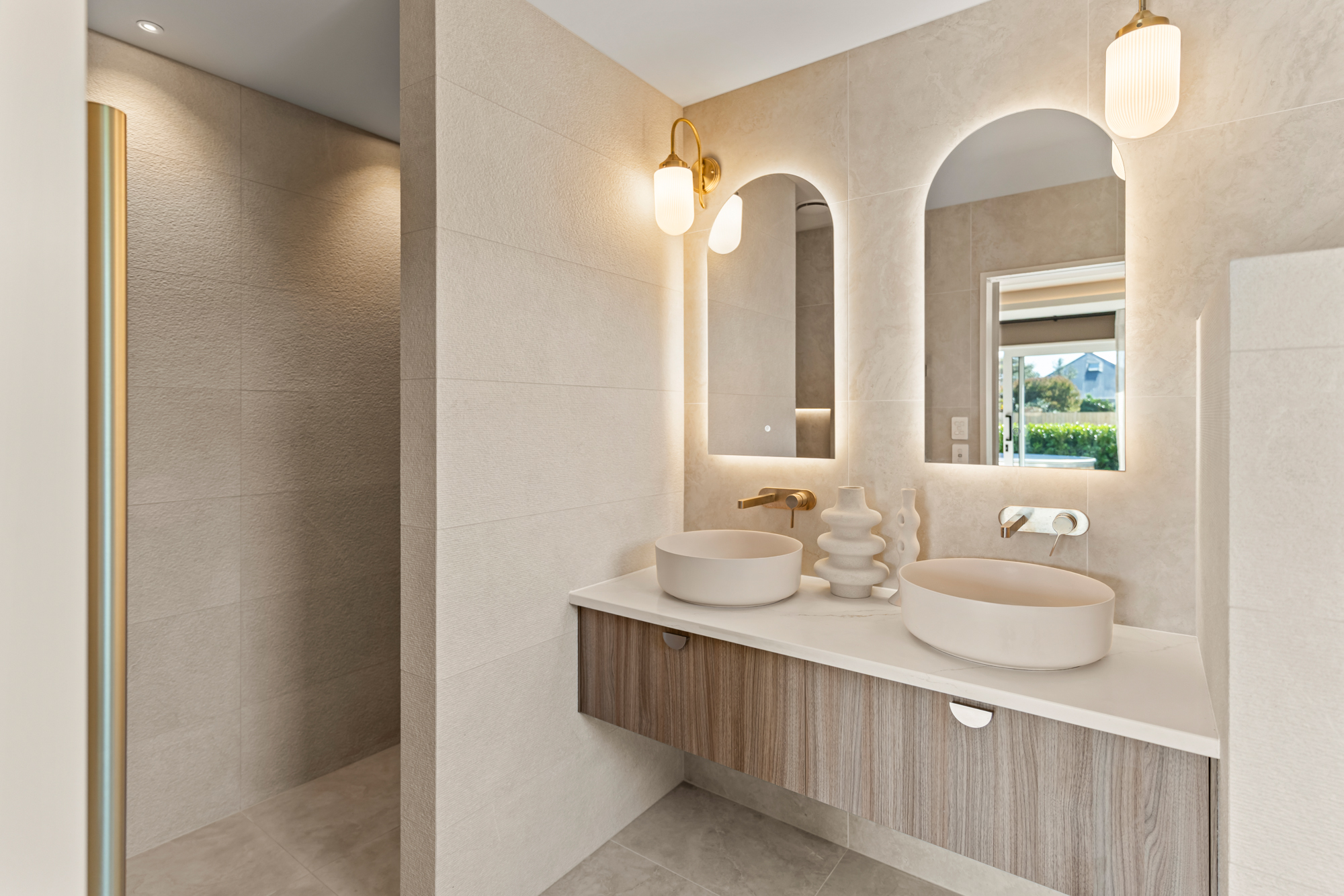 Marine Parade - guest ensuite with double arched mirrors, brass tapware, and stone tiles