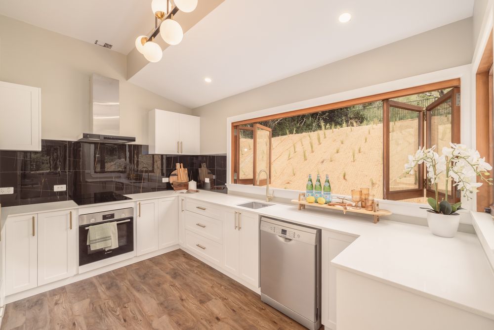 Port Hills Road kitchen with dark splashback and timber windows